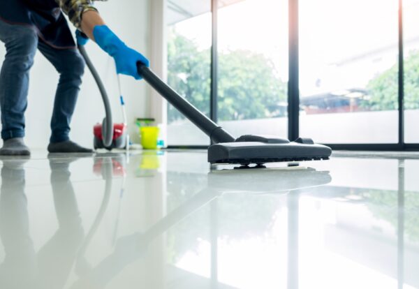 Young attractive man is cleaning vacuum commercial cleaning equipment on floor at home helping wife Young attractive man is cleaning vacuum commercial cleaning equipment on floor at home helping wife